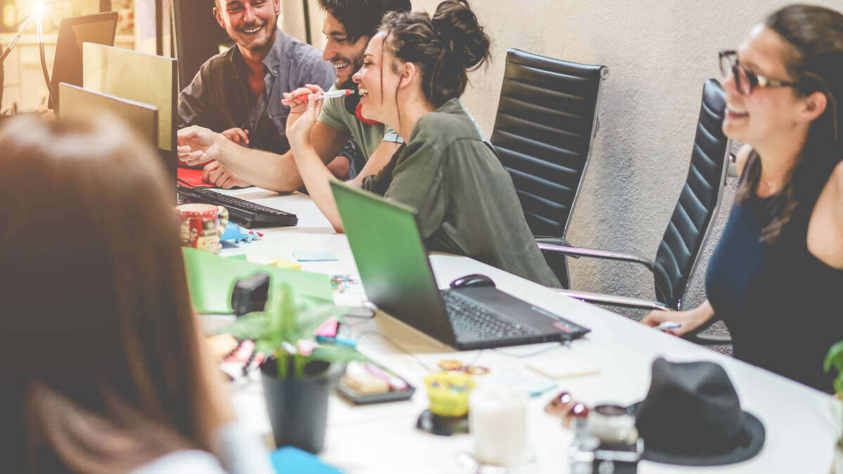 Young marketing team laughs around conference table