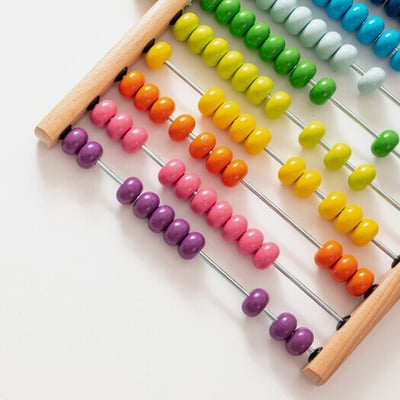 Colorful wooden beads on child math counter tool.